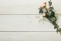 Roses and golden rings on white wood, wedding background