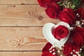 Roses with heart shape coffee cup on wooden background. View from above