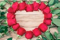 Roses laid out in the shape of a heart on a wooden background. With free space for text. Festive background. Valentine`s Day