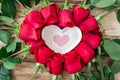 Roses laid out in the shape of a heart on a wooden background, among them a plate in the shape of a heart and with the inscription Royalty Free Stock Photo