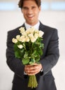 Roses mean love. Portrait of a handsome young man wearing a suit and holding a bunch of roses.