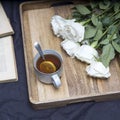 Roses Playa blanca is with cup of tea with lemon on the wooden tray on the grey shirt Royalty Free Stock Photo