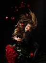 Roses for Valentines day. Holiday birthday present. Beautiful seductive woman holding large bouquet of red roses on Royalty Free Stock Photo