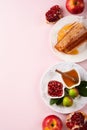 Rosh Hashanah. Honey jar, honeycomb, apple and pomegranate on simple pink background. Jewish New Year holiday greeting card. Rosh Royalty Free Stock Photo