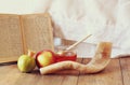 Rosh hashanah (jewesh holiday) concept - honey, apple and pomegranate over wooden table. traditional holiday symbols.