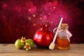 Rosh hashanah (jewesh holiday) concept - honey and pomegranate over wooden table. traditional holiday symbols.