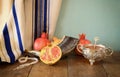 Rosh hashanah (jewesh holiday) concept - shofar, honey, apple and pomegranate over wooden table. traditional holiday symbols.