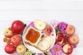 Rosh hashanah jewish holiday concept with apples, honey, pomegranate and dried apricots on bright white background, top view with Royalty Free Stock Photo