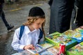 Rosh Hashanah, Jewish New Year 5777. Festive street trade. A Hasid child with long payos chooses a book.