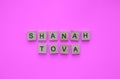 Rosh Hashanah, minimalistic banner with the inscription in wooden letters on a pink background Royalty Free Stock Photo