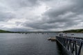 The Rosmoney Pier and dock with many sailboats and yachts anchored in the waters of Clew Bay under an overcast sky