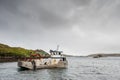 Rosroe Pier, county Galway, Ireland 07/14/2020: Small boat with fish feed on board, Fish industry. Cloudy low sky