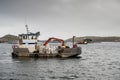 Rosroe Pier, county Galway, Ireland 07/14/2020: Small boat with fish feed on board, Fish industry. Cloudy low sky
