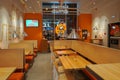 Empty Dodo Pizza fast food restaurant. Pizzeria interior branded in company orange colors. Royalty Free Stock Photo