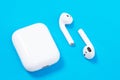 Rostov, Russia - July 06, 2020: Apple AirPods wireless Bluetooth headphones and charging case for Apple iPhone lie on a blue Royalty Free Stock Photo