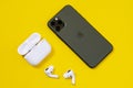 Rostov, Russia - July 06, 2020: Smartphone Apple iPhone 11 Pro of Midnight Green color and wireless headphones with opened
