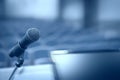 Rostrum with microphone and computer in conference hall with motion blur effect