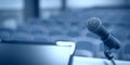 Rostrum with microphone and computer in conference room Royalty Free Stock Photo