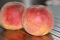 Rosy ripe Kuban peach close-up on a metal table