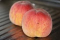 Rosy ripe Kuban peach close-up on a metal table