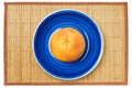 Rosy yellow grapefruit on a blue plate on a cane place mat