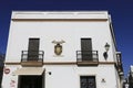 Whitewashed facade with carved stone coat of arms in Rota city, Andalusia