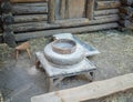 Rotary discoid mill stone for hand-grinding a grain into flour. Medieval hand-driven millstone grinding wheat. The Royalty Free Stock Photo