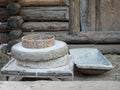 Rotary discoid mill stone for hand-grinding a grain into flour. Medieval hand-driven millstone grinding wheat. The Royalty Free Stock Photo