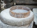 Rotary discoid mill stone for hand-grinding a grain into flour. Medieval hand-driven millstone grinding wheat. The Royalty Free Stock Photo