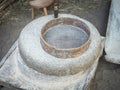 Rotary discoid mill stone for hand-grinding a grain into flour. Medieval hand-driven millstone grinding wheat. The Royalty Free Stock Photo