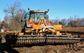 Rotary harrow machine trailed by a tractor on an agricultural field to prepare the soil for the seeding. Royalty Free Stock Photo