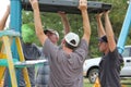 Rotary members from the community helping to build a playground for children.