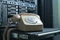 rotary phone, which stands against background of a server cabinet