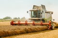 Rotary straw walker cut and threshes ripe wheat grain. Man in combine harvesters with grain header, wide chaff spreader