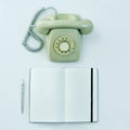 Rotary telephone, pen and blank notepad on a table Royalty Free Stock Photo
