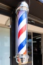 Rotating barber pole with red white blue stripes hair salon shop sign Royalty Free Stock Photo