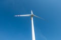 Rotating blades of a windmill propeller on blue sky background. Wind power generation. Pure green energy Royalty Free Stock Photo