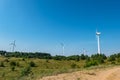 Rotating blades of a windmill propeller on blue sky background. Wind power generation. Pure green energy Royalty Free Stock Photo