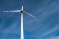 Rotating blades of a windmill propeller on blue sky background. Wind power generation. Pure green energy Royalty Free Stock Photo