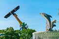 Rotating merry-go-round in the sky with a dolphin-shaped fountain in amusement park