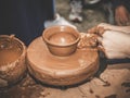 Rotating potter`s wheel and clay ware on it taken from above. A child sculpts his hands with a clay cup on a potter`s Royalty Free Stock Photo