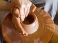 Rotating potter`s wheel and clay ware on it vase : taken from above. Hands in clay. Pottery: male ceramist creates a Royalty Free Stock Photo