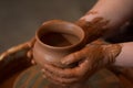 Rotating potter`s wheel and clay ware on it taken from above. A sculpts his hands with a clay cup. Hands in clay. Royalty Free Stock Photo