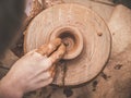 Rotating potter`s wheel and clay ware on it taken from above. A sculpts his hands with a clay cup on a potter`s wheel Royalty Free Stock Photo