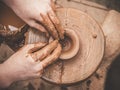 Rotating potter`s wheel and clay ware on it taken from above. A sculpts his hands with a clay cup on a potter`s wheel Royalty Free Stock Photo