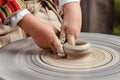 Rotating potter`s wheel and clay ware on it taken from above. A sculpts his hands with a clay cup on a potter`s wheel. Royalty Free Stock Photo