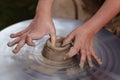 Rotating potter`s wheel and clay ware on it taken from above. A sculpts his hands with a clay cup on a potter`s wheel. Royalty Free Stock Photo