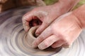 Rotating potter`s wheel and clay ware on it taken from above. A sculpts his hands with a clay cup on a potter`s wheel. Royalty Free Stock Photo