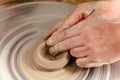 Rotating potter`s wheel and clay ware on it taken from above. A sculpts his hands with a clay cup on a potter`s wheel. Hands in Royalty Free Stock Photo