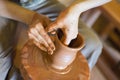 Rotating potter`s wheel and clay ware on it vase : taken from above. Hands in clay. Pottery: male ceramist creates a Royalty Free Stock Photo